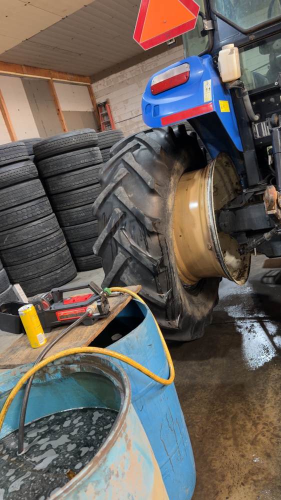 Tractor tire being fluid-filled on site for added weight and traction