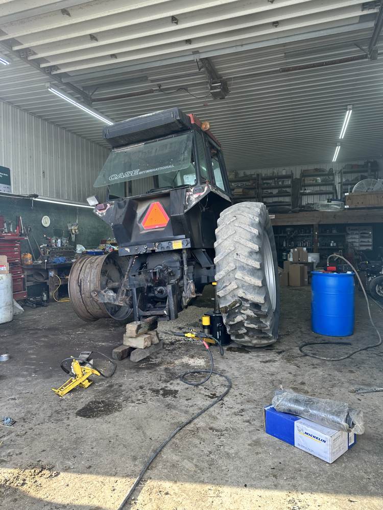 Case International farm tractor jacked up in the shop for tire service